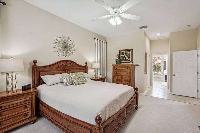 bedroom with light tile patterned floors, connected bathroom, visible vents, and light colored carpet