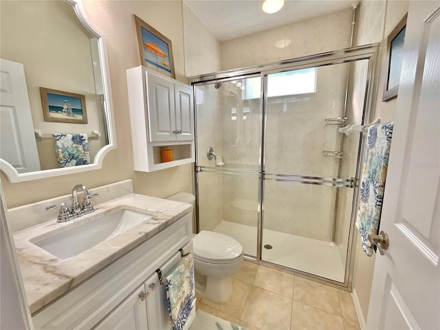 bathroom with vanity, a shower with door, tile patterned floors, and toilet