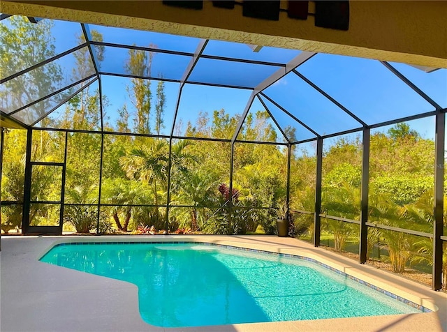 view of swimming pool featuring a lanai and a patio area