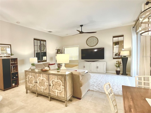 living area with a ceiling fan, visible vents, and light tile patterned floors