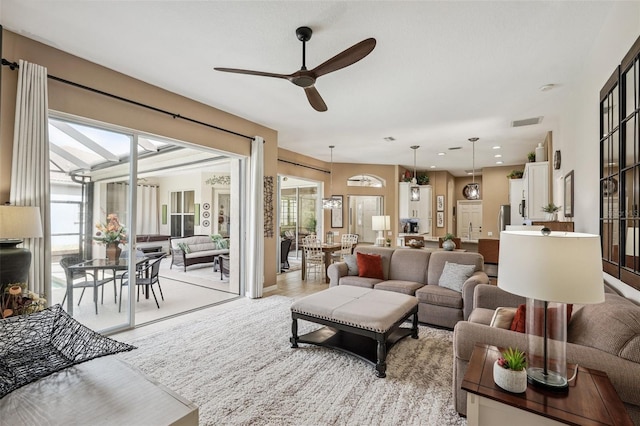 living area with ceiling fan and visible vents