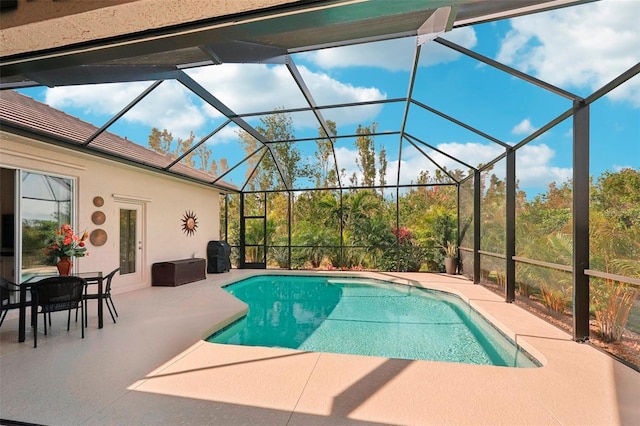 outdoor pool with glass enclosure and a patio area