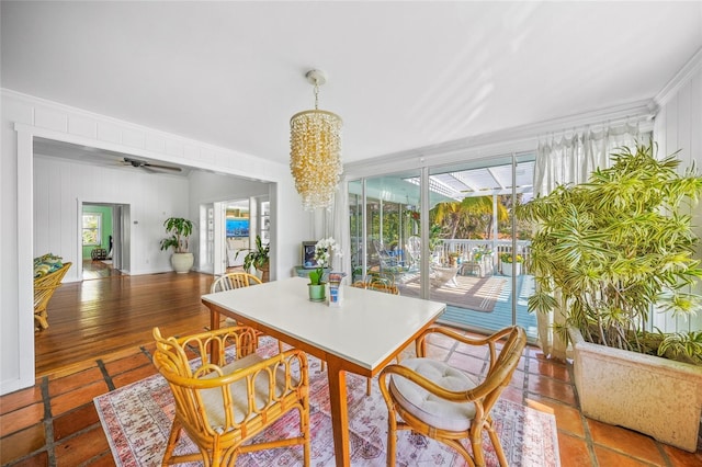 sunroom / solarium with ceiling fan with notable chandelier