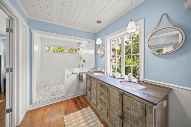 bathroom featuring hardwood / wood-style flooring, ornamental molding, vanity, tiled shower, and wood ceiling