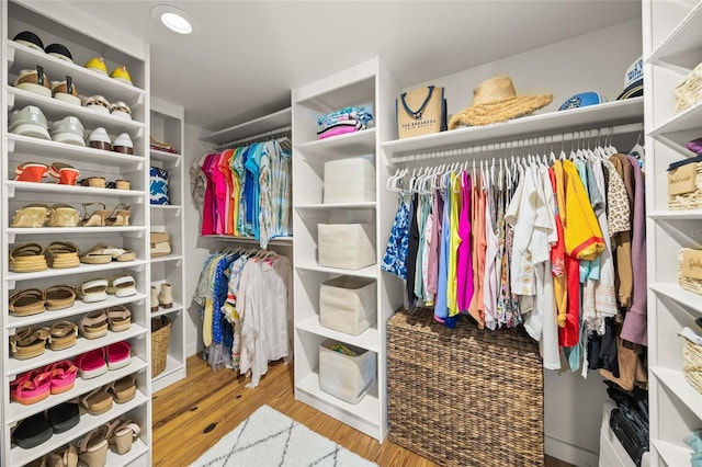 walk in closet with light hardwood / wood-style flooring