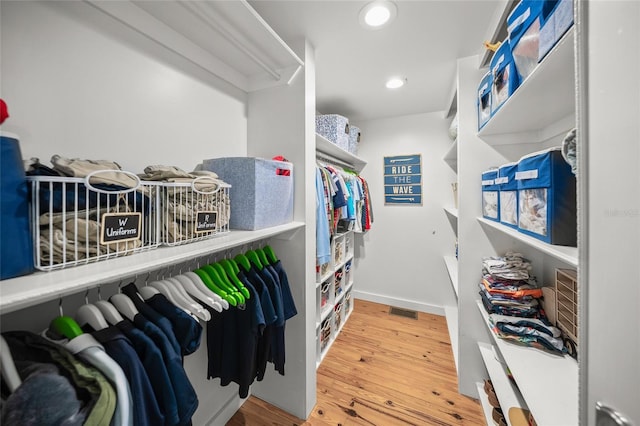 walk in closet with hardwood / wood-style flooring