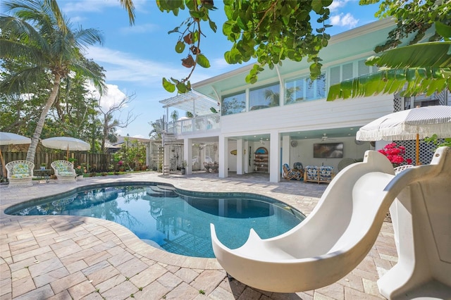 view of swimming pool featuring a water slide and a patio area