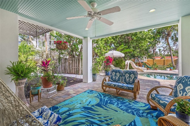 view of patio / terrace with ceiling fan, an outdoor living space, and a playground