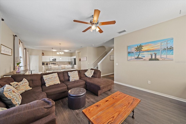 living room featuring dark hardwood / wood-style flooring and ceiling fan with notable chandelier