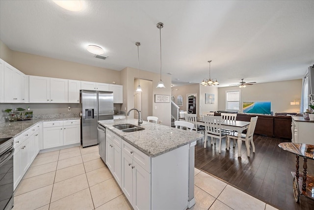 kitchen with pendant lighting, white cabinetry, sink, a kitchen island with sink, and stainless steel appliances