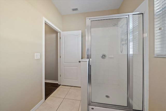 bathroom with tile patterned floors and a shower with shower door