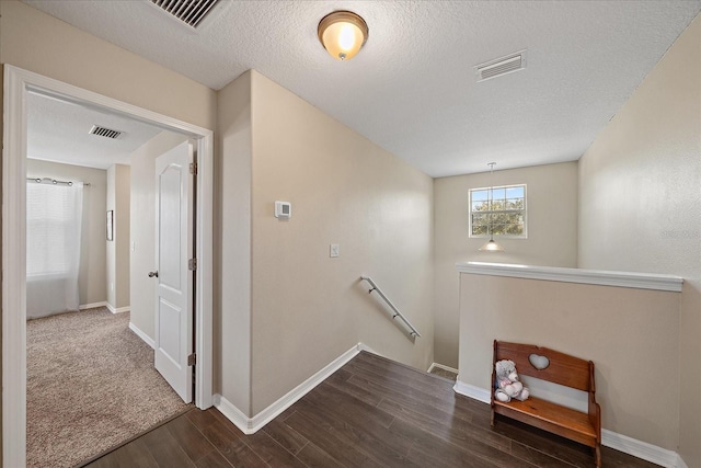 stairway featuring hardwood / wood-style flooring and a textured ceiling