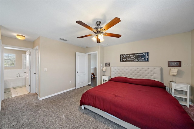 bedroom with ceiling fan, ensuite bathroom, carpet flooring, and a textured ceiling