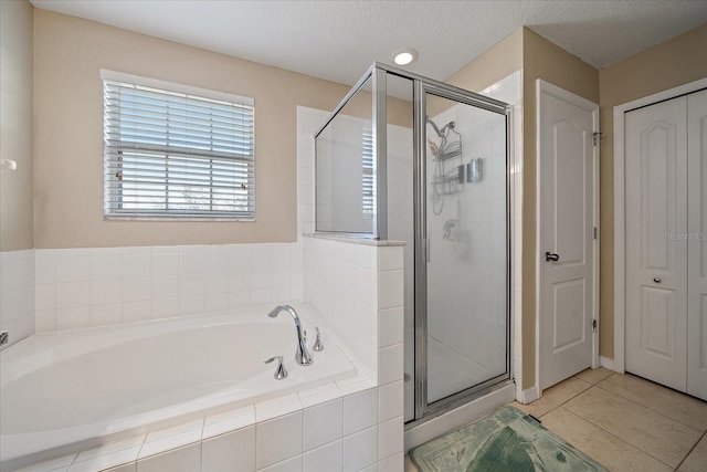 bathroom featuring tile patterned floors, shower with separate bathtub, and a textured ceiling