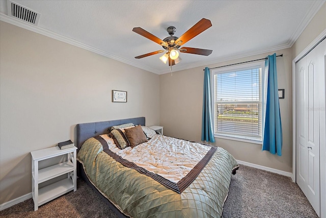 carpeted bedroom featuring ornamental molding, ceiling fan, and a closet