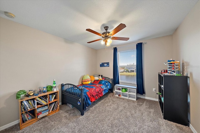 carpeted bedroom with ceiling fan and a textured ceiling