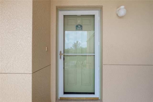 property entrance with stucco siding