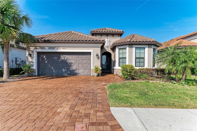 mediterranean / spanish house featuring a garage and a front yard