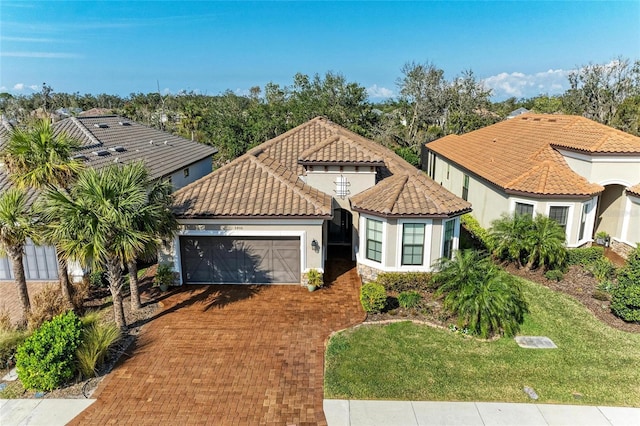 mediterranean / spanish-style house featuring a garage and a front lawn