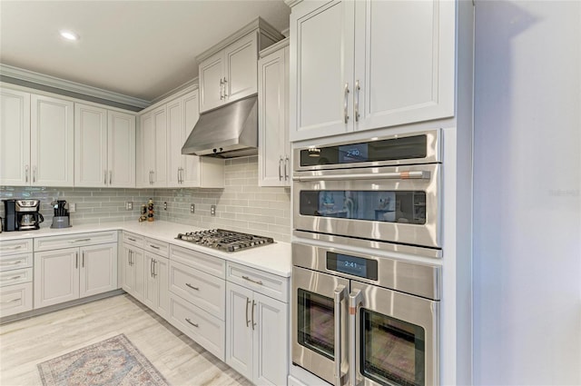 kitchen featuring decorative backsplash, stainless steel appliances, and light wood-type flooring