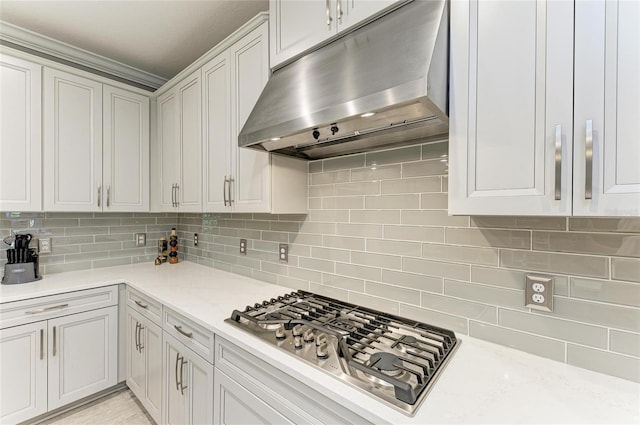 kitchen featuring stainless steel gas stovetop, tasteful backsplash, light stone countertops, and white cabinets