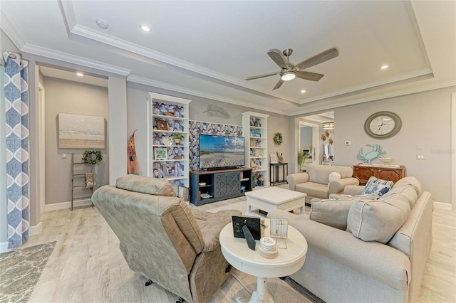 living room with crown molding, light hardwood / wood-style flooring, a raised ceiling, and ceiling fan