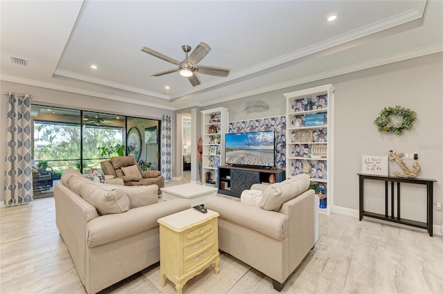 living room with crown molding, light hardwood / wood-style floors, a raised ceiling, and ceiling fan