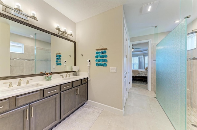 bathroom with vanity, tile patterned floors, a healthy amount of sunlight, and a tile shower