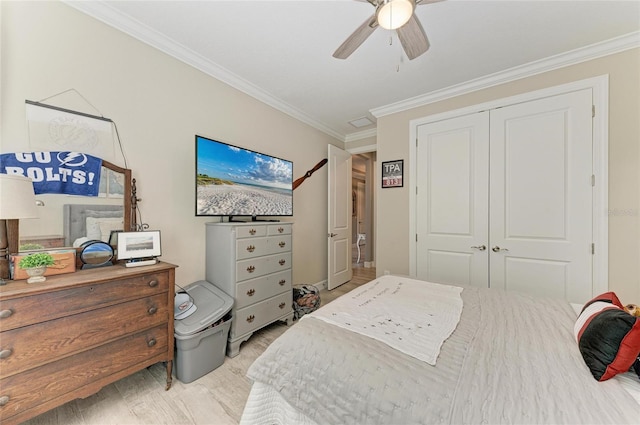 bedroom with crown molding, ceiling fan, and a closet