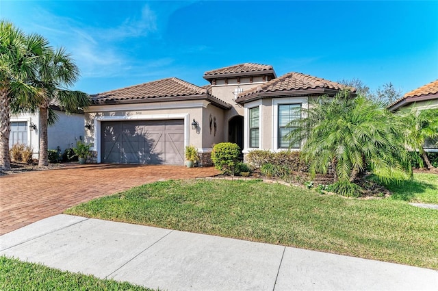 mediterranean / spanish home featuring a garage and a front lawn