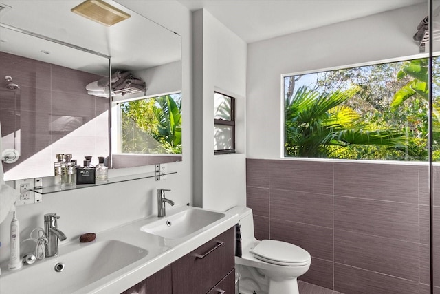 bathroom featuring a wealth of natural light, tile walls, vanity, and toilet