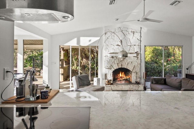 living room featuring vaulted ceiling, ceiling fan, and a fireplace