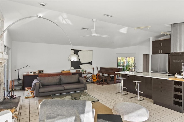 tiled living room with vaulted ceiling, sink, track lighting, and ceiling fan