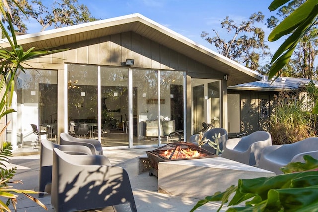 rear view of house with a fire pit and a patio area