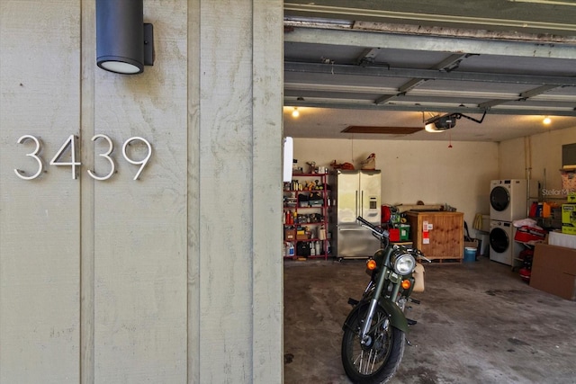 garage featuring stacked washer and dryer, a garage door opener, and stainless steel fridge with ice dispenser