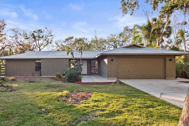 ranch-style home featuring a garage and a front lawn