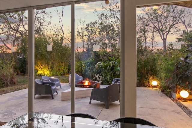 patio terrace at dusk featuring an outdoor fire pit