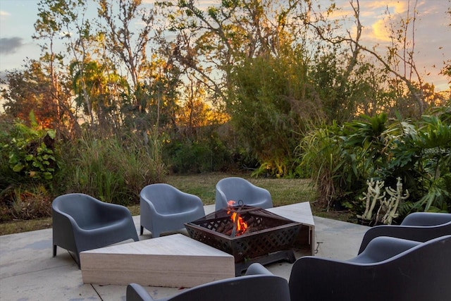 patio terrace at dusk featuring an outdoor fire pit