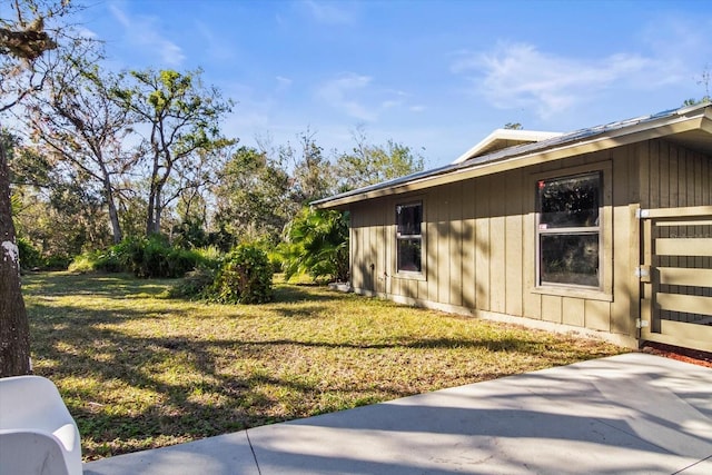 view of property exterior featuring a lawn and a patio area