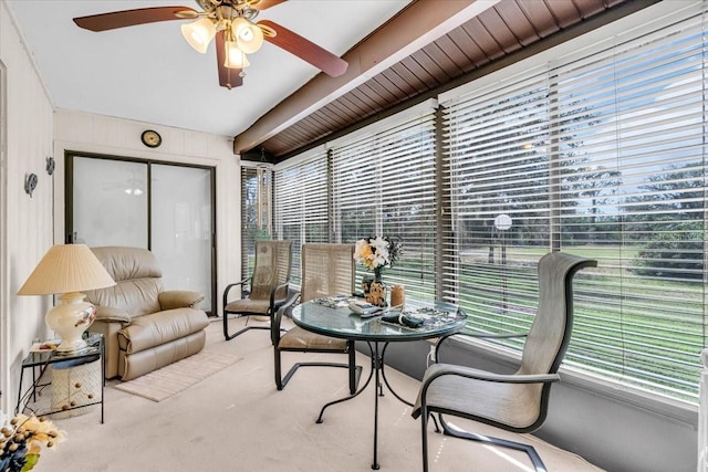 sunroom featuring beamed ceiling and a ceiling fan