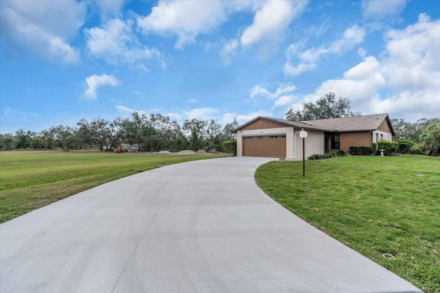 ranch-style home featuring an attached garage, concrete driveway, and a front yard