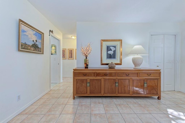 hall featuring a barn door and light tile patterned floors