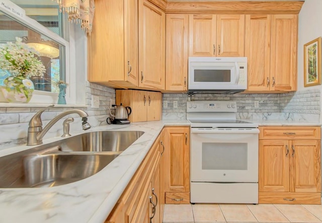 kitchen featuring sink, white appliances, light tile patterned floors, and light brown cabinets