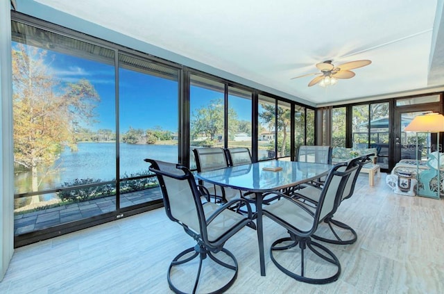 sunroom / solarium featuring ceiling fan, a healthy amount of sunlight, and a water view