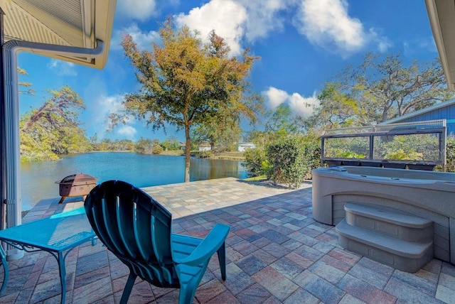 view of patio featuring a water view and a hot tub