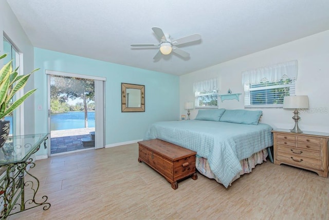 bedroom with ceiling fan, access to exterior, light hardwood / wood-style floors, and multiple windows