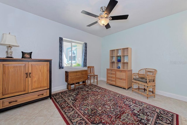 living area with light tile patterned floors and ceiling fan