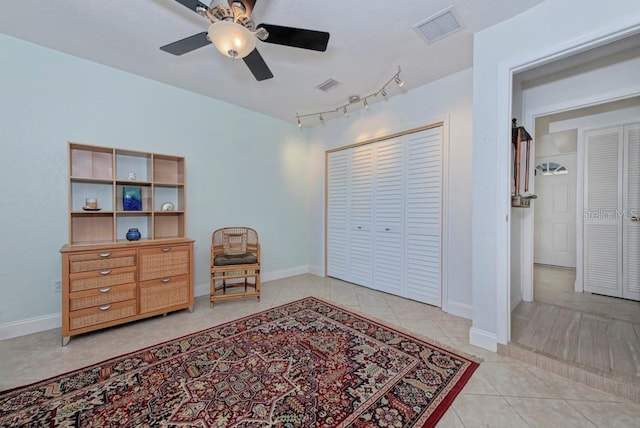 living area featuring rail lighting, light tile patterned floors, and ceiling fan