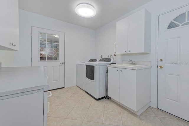 laundry room featuring light tile patterned flooring, cabinets, sink, and washer and dryer