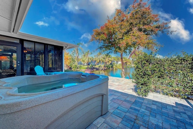 view of patio featuring a hot tub and a water view